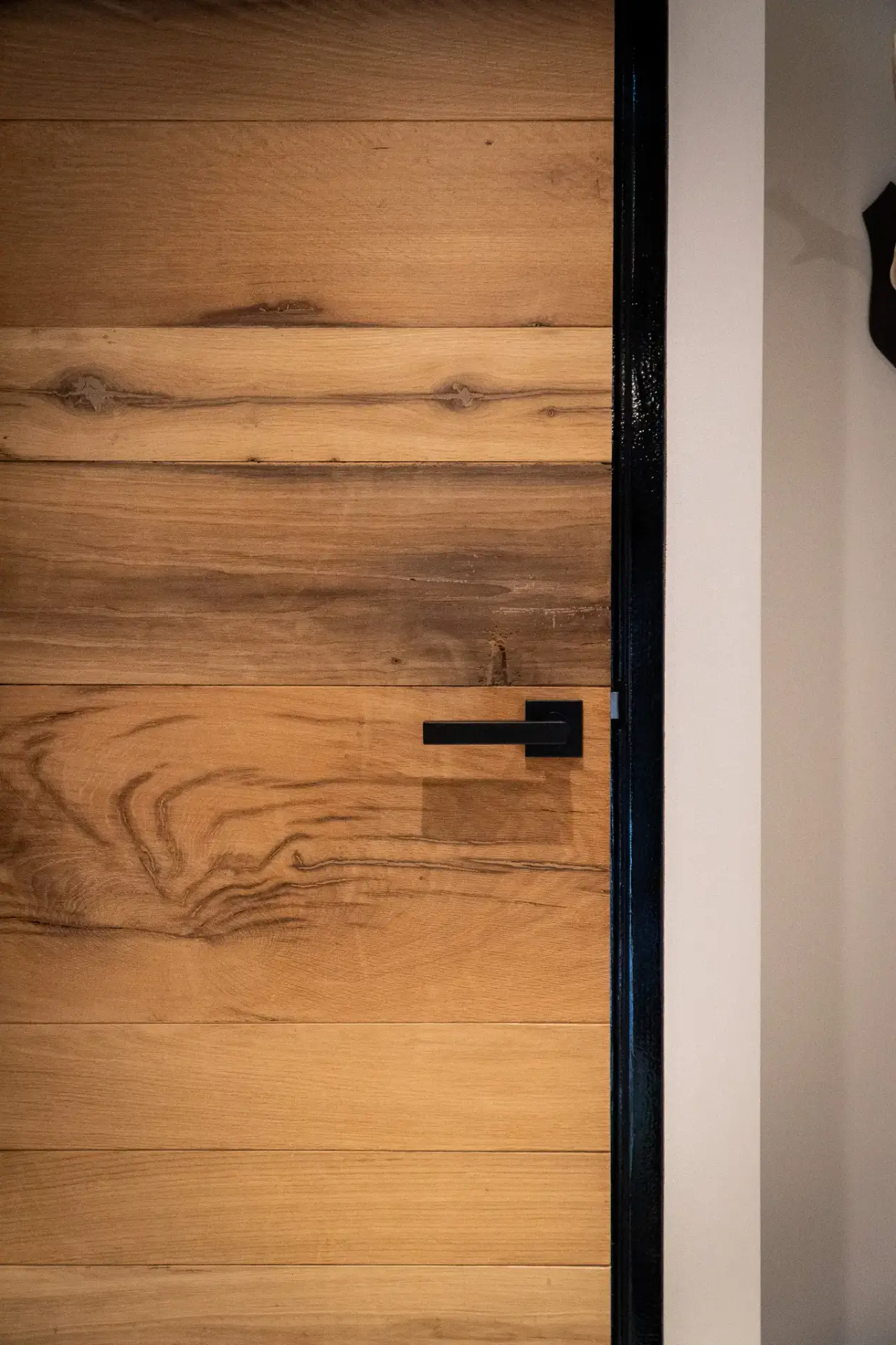 Massieve deur van gerecycled oud hout met zichtbare nerf en warme tinten.