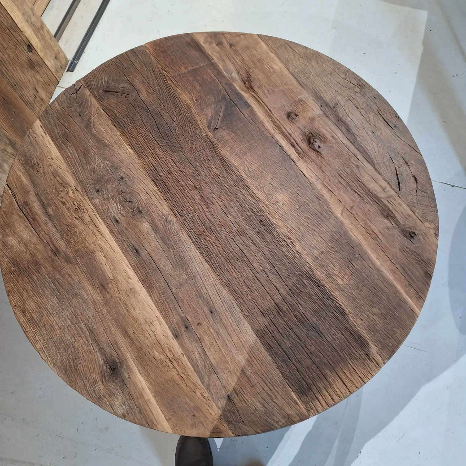Detail van oud eikenhout bij ronde eettafel met doorleefde structuur