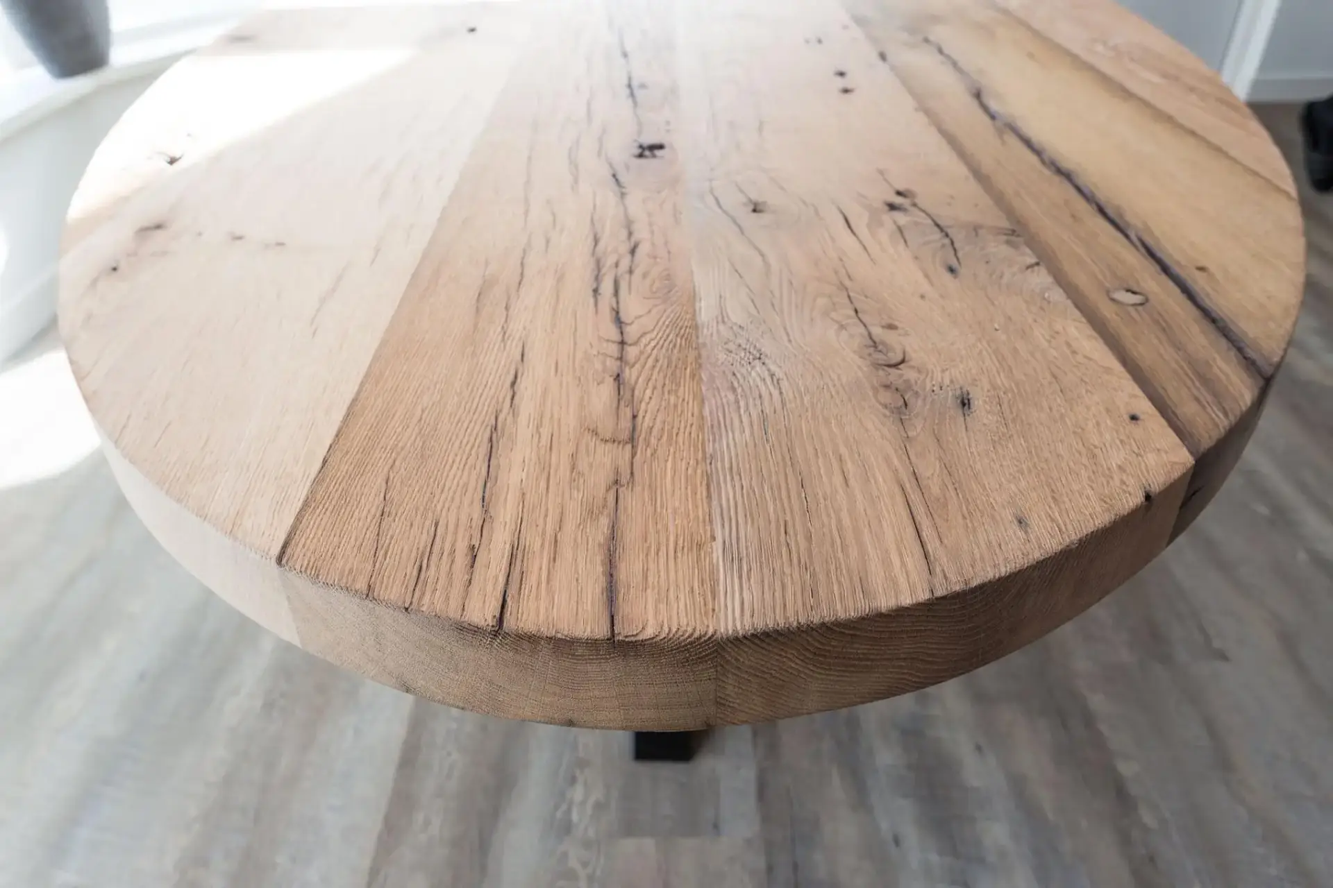 Detail van oud eikenhout bij ronde eettafel met doorleefde structuur