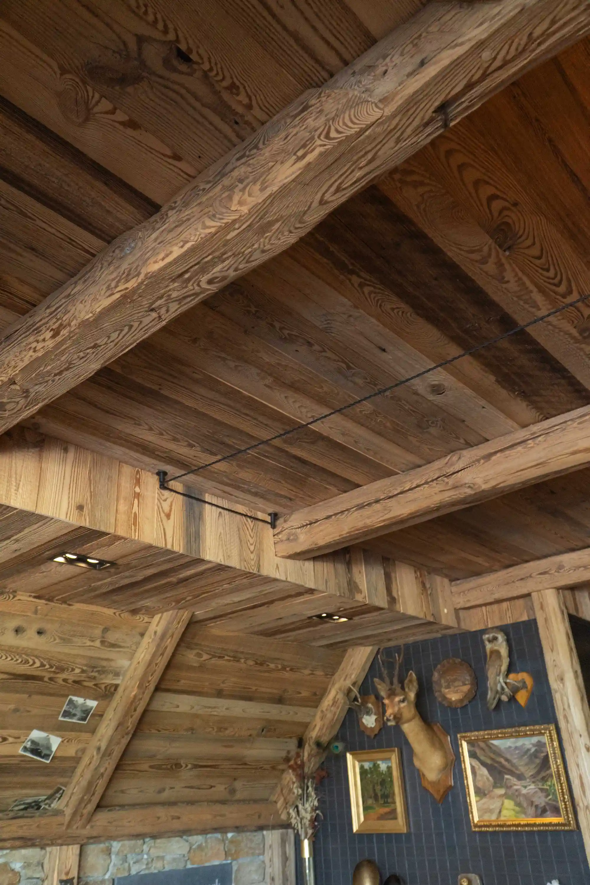 Oud grenen plafondbekleding en balken met een warme uitstraling en karaktervolle houtstructuur.