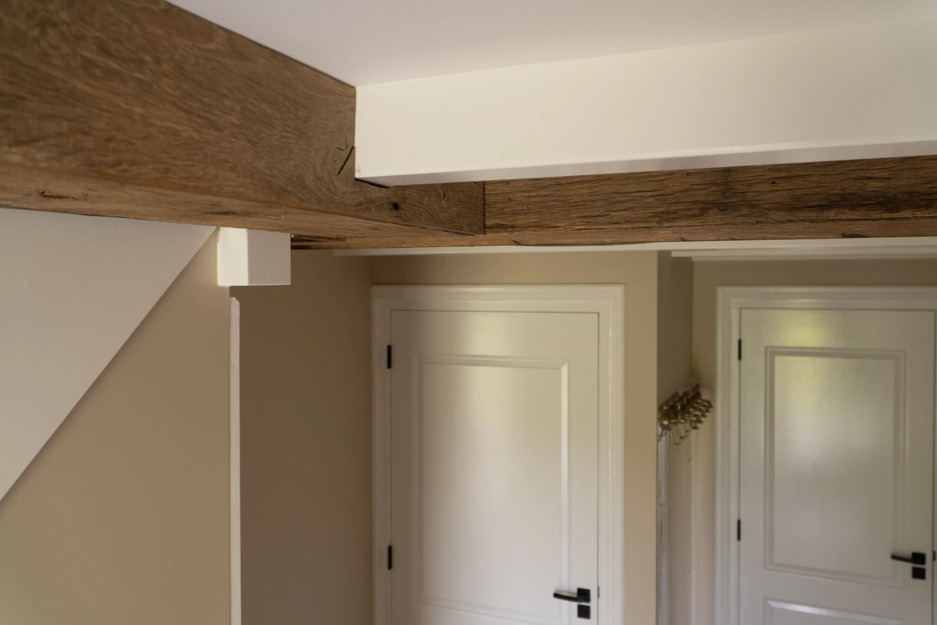 Oude eiken balkbekleding verwerkt in een wit plafond