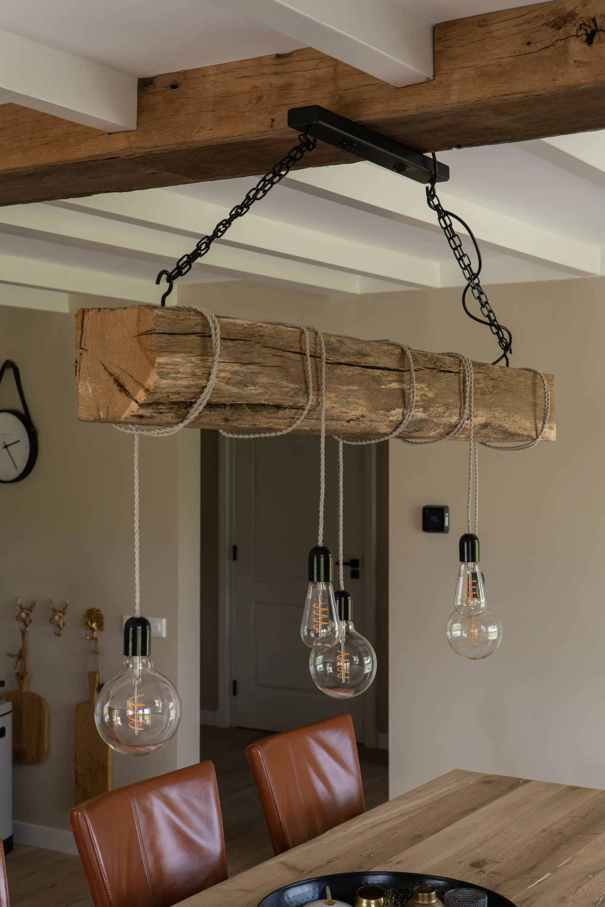 Eiken balk met verlichting boven een eiken tafel