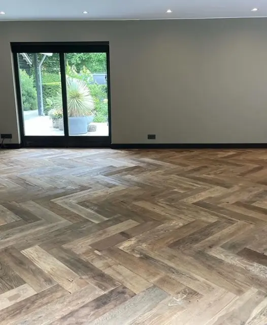 Oud eiken visgraatvloer met warme kleurschakeringen en zichtbare houtnerf.