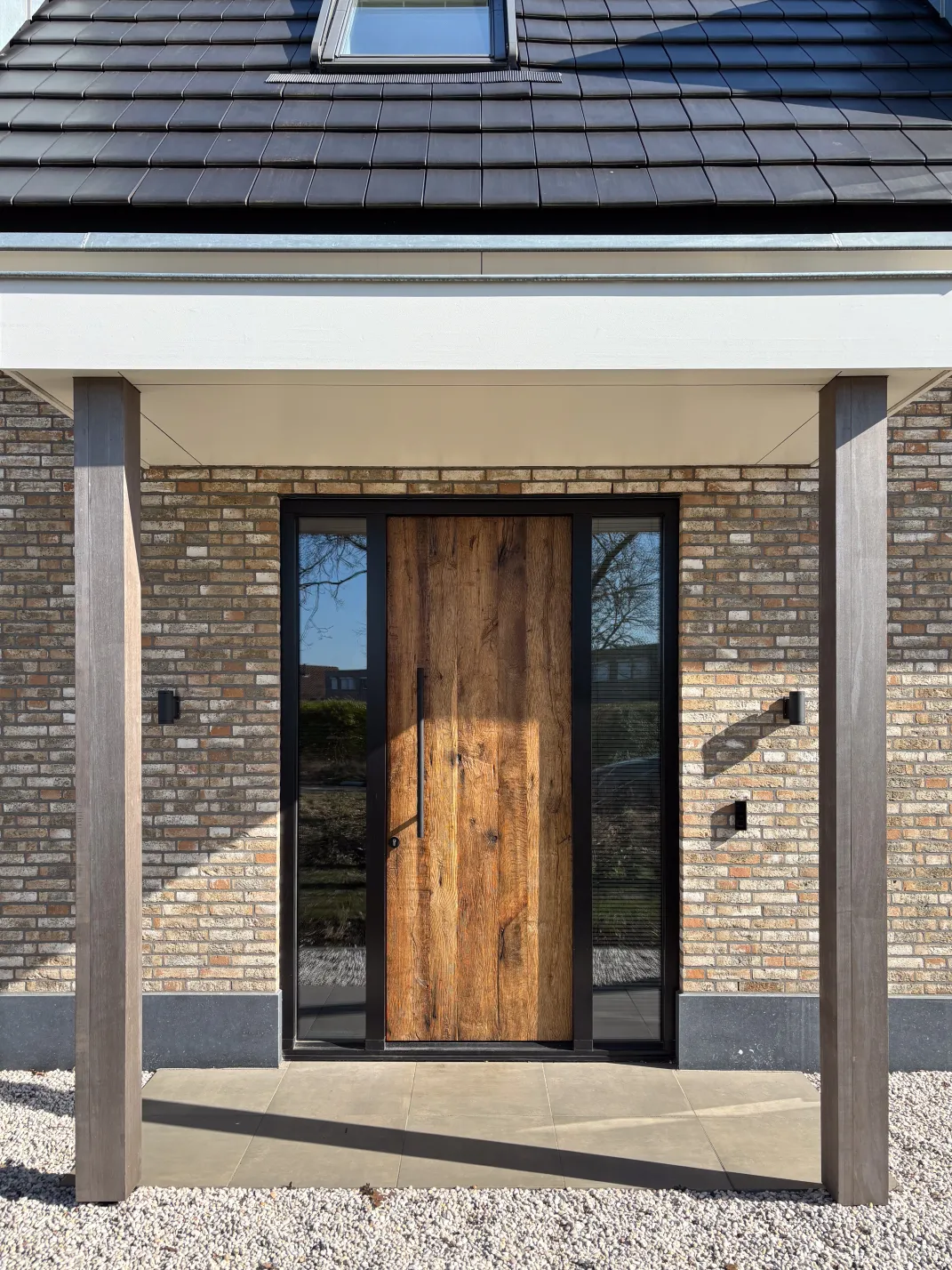 Moderne entree met een robuuste voordeur van oud eikenhout